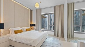 A modern hotel room with a large bed, a bedside table, a lamp, and a view of the city through large windows. - SIMPLY COMFORT Luxury Burj Khalifa & Fountain View Apartments Steps to Dubai Mall (Dubai)