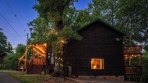 Uma cabana de toras com varanda, escadaria e deck.