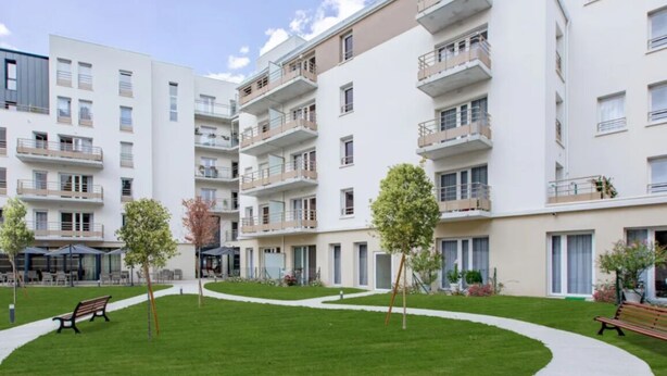 A modern apartment building with multiple balconies, a central grassy courtyard, and benches. -  ZENAO Appart'hôtels Dijon (Dijon)