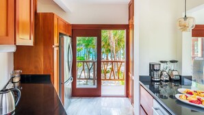 Eine moderne Küche mit Holzausstattung, einem Edelstahlkocher, einem Mixer und einer Kaffeemaschine.
