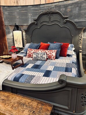 Un lit avec une couette, des oreillers et une tête de lit décorative.
