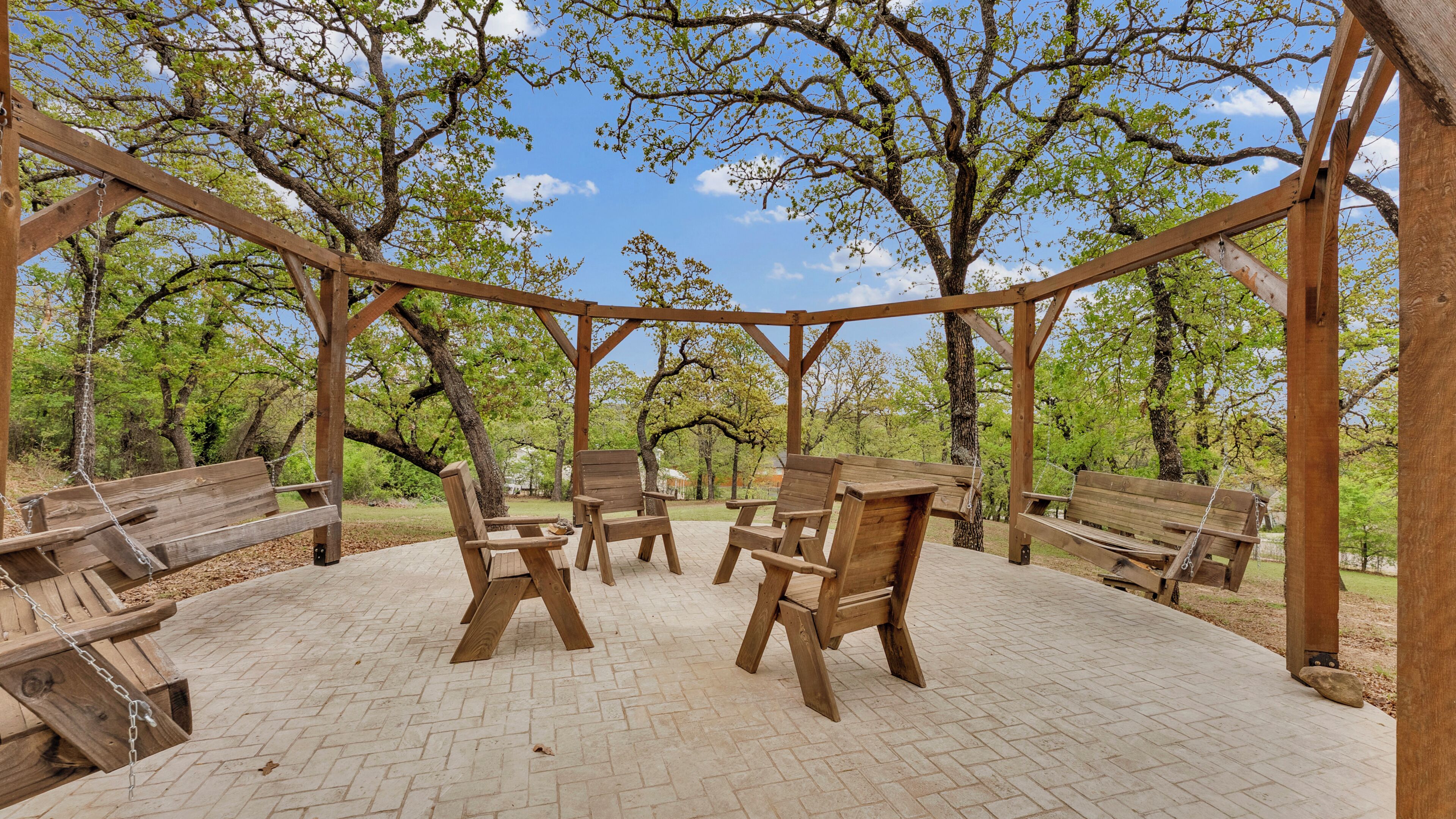 Une pergola en bois, agrémentée de bancs et de chaises, située dans un parc.