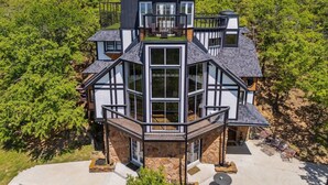 A multi-story house with a stone facade, large windows, and a balcony. - Highest House in All of Fort Worth - Luxury Family Getaway with Stunning Views (Joshua)