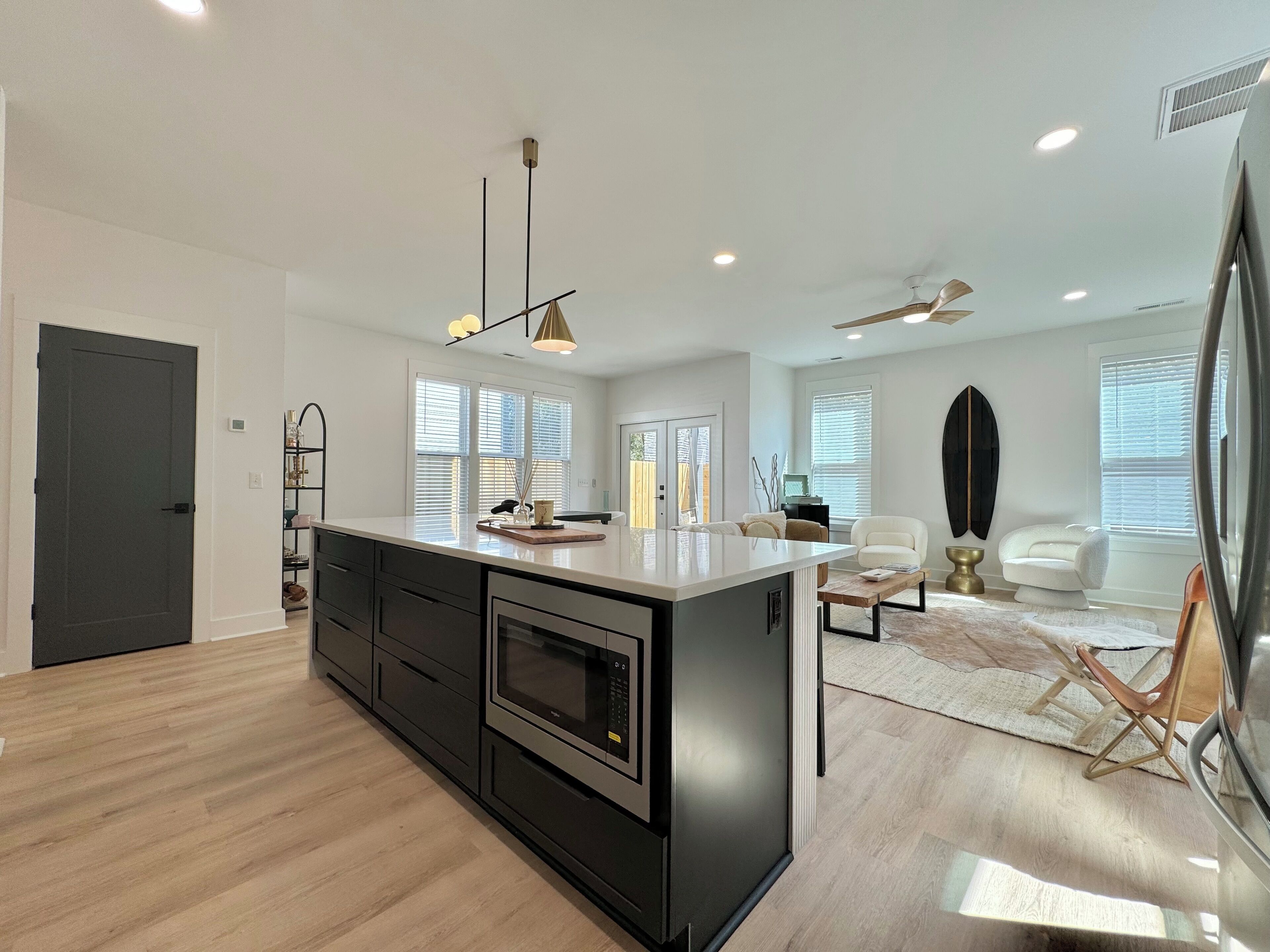 A modern kitchen with a central island, built-in appliances, and pendant lighting.