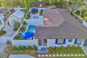 A house with a swimming pool, a covered patio, and a fenced yard.
