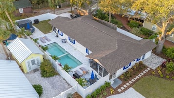 A two-story house with a swimming pool, a fenced backyard, and a small shed.