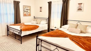 A hotel room with two beds, a bedside table, a nightstand, and a ceiling light fixture. - Palm Oasis 2/2 Serene Backyard Private Poolside (St. Petersburg)