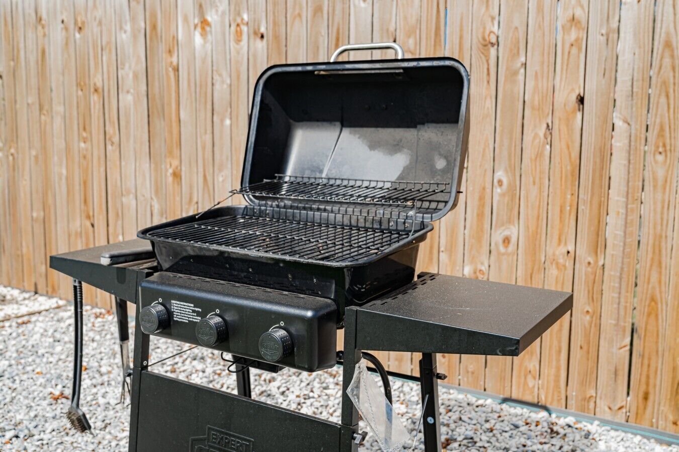 A portable grill with a lid, control knobs, and a handle.