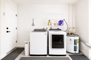 Une buanderie équipée de deux machines à laver et d’un chauffe-eau.