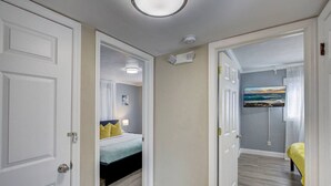 A bedroom with a bed, bedside table, and a painting on the wall. - Villa Bella with Heated Pool (Largo)