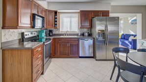 A modern kitchen with wooden cabinets, stainless steel appliances, and a tiled floor. - Villa Bella with Heated Pool (Largo)