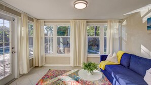 A room with a blue sofa, a colorful rug, and a white coffee table with a plant. - Villa Bella with Heated Pool (Largo)