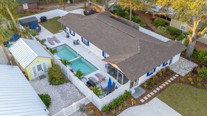 A two-story house with a swimming pool, a fenced backyard, and a front porch.
