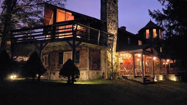A modern house with a stone chimney, a balcony, and a lit interior. - The Golden Eagle Vacation Rental, a 3 minute walk to Timberline Ski Slopes (Davis)