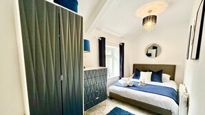 Una camera da letto con un letto, una cassettiera, una finestra e una lampada a soffitto.