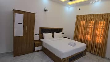 Quarto moderno com cama, guarda-roupa, ventoinha no teto e janela com cortinas.