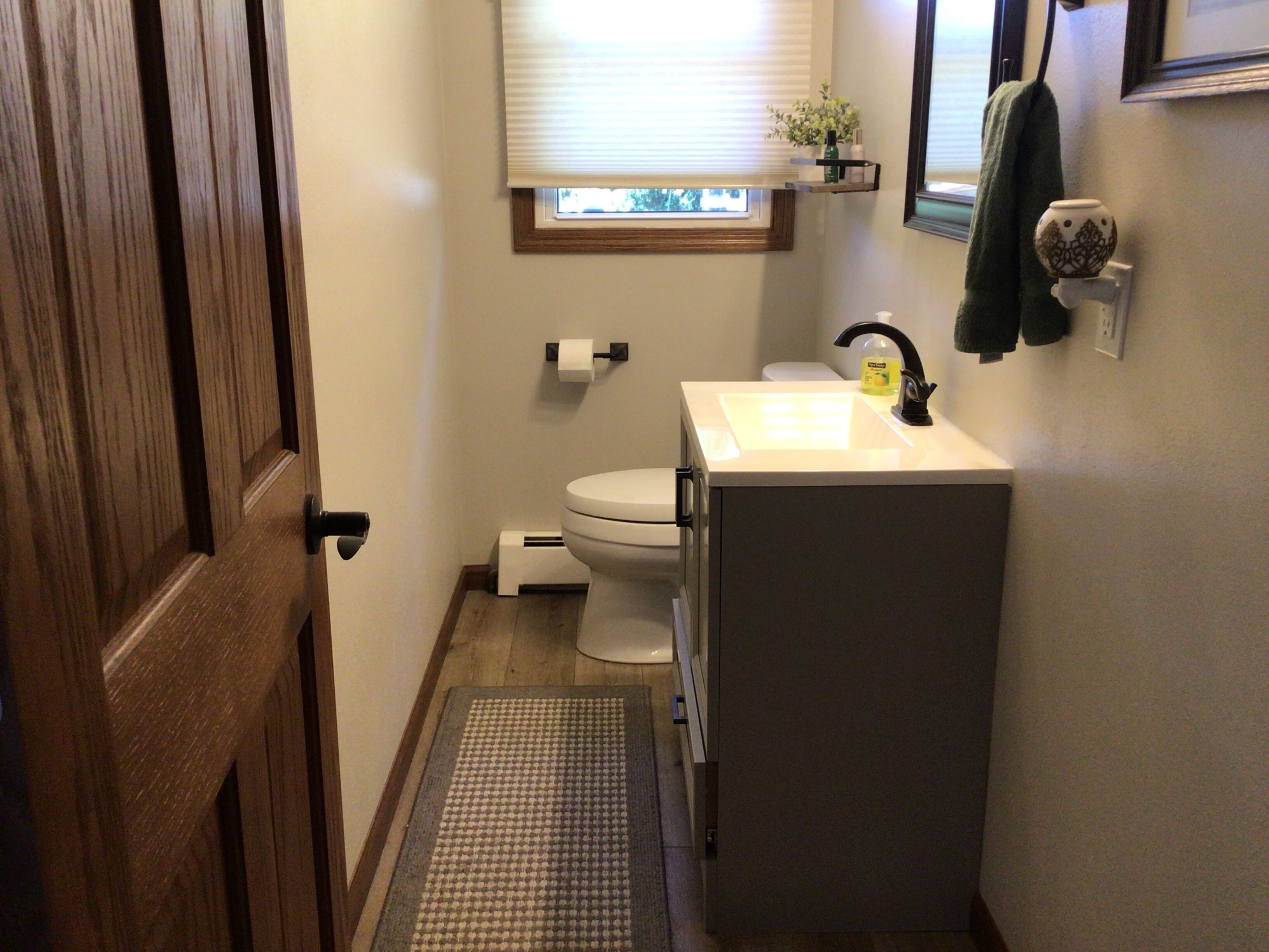 Un baño pequeño con inodoro, lavamanos y ventana.