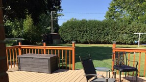 Une terrasse dotée d’un barbecue intégré, de deux chaises et d’une table.