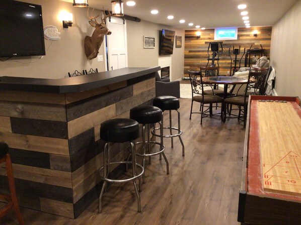 A bar area with stools, a dartboard, and a mounted deer head. - EAA 3 bedroom house in Oshkosh (Oshkosh)