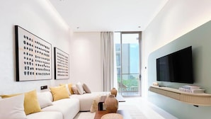 Uma sala de estar moderna com um sofá, uma mesa de centro e uma TV de tela plana.