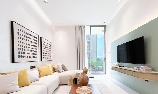 Una sala de estar moderna con un sofá, una mesa de centro y un televisor de pantalla plana.