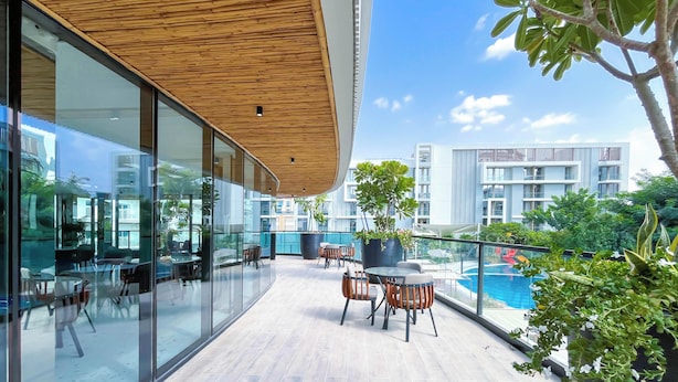 Terraço moderno ao ar livre com paredes de vidro, teto de madeira e área de piscina.