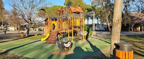 Ein Spielplatz mit Rutsche, Klettergerüsten und einem Spielbereich im Pinguin-Design.