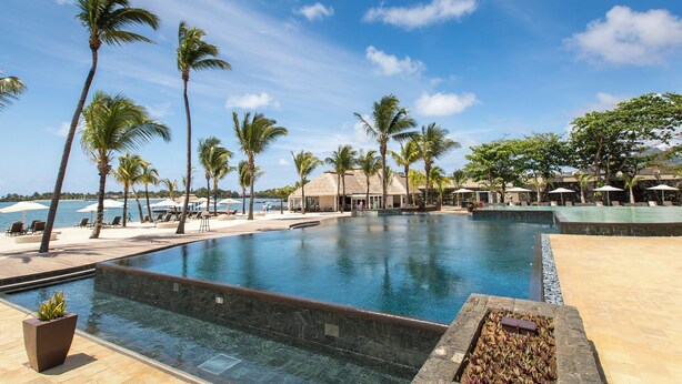 A resort pool with palm trees, lounge chairs, and umbrellas. - Apartment at Anahita 5*Resort : golf & access to Ile aux Cerfs exclusive beach 4 (Beau Champ)