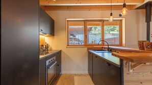 Una cocina moderna con electrodomésticos de acero inoxidable, armarios de madera y un ventanal con vistas al exterior.