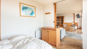 Un dormitorio con cama, armario de madera y un cuadro en la pared.