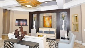 Un salon moderne avec un canapé blanc, une table basse et une pièce maîtresse sculpturale originale.