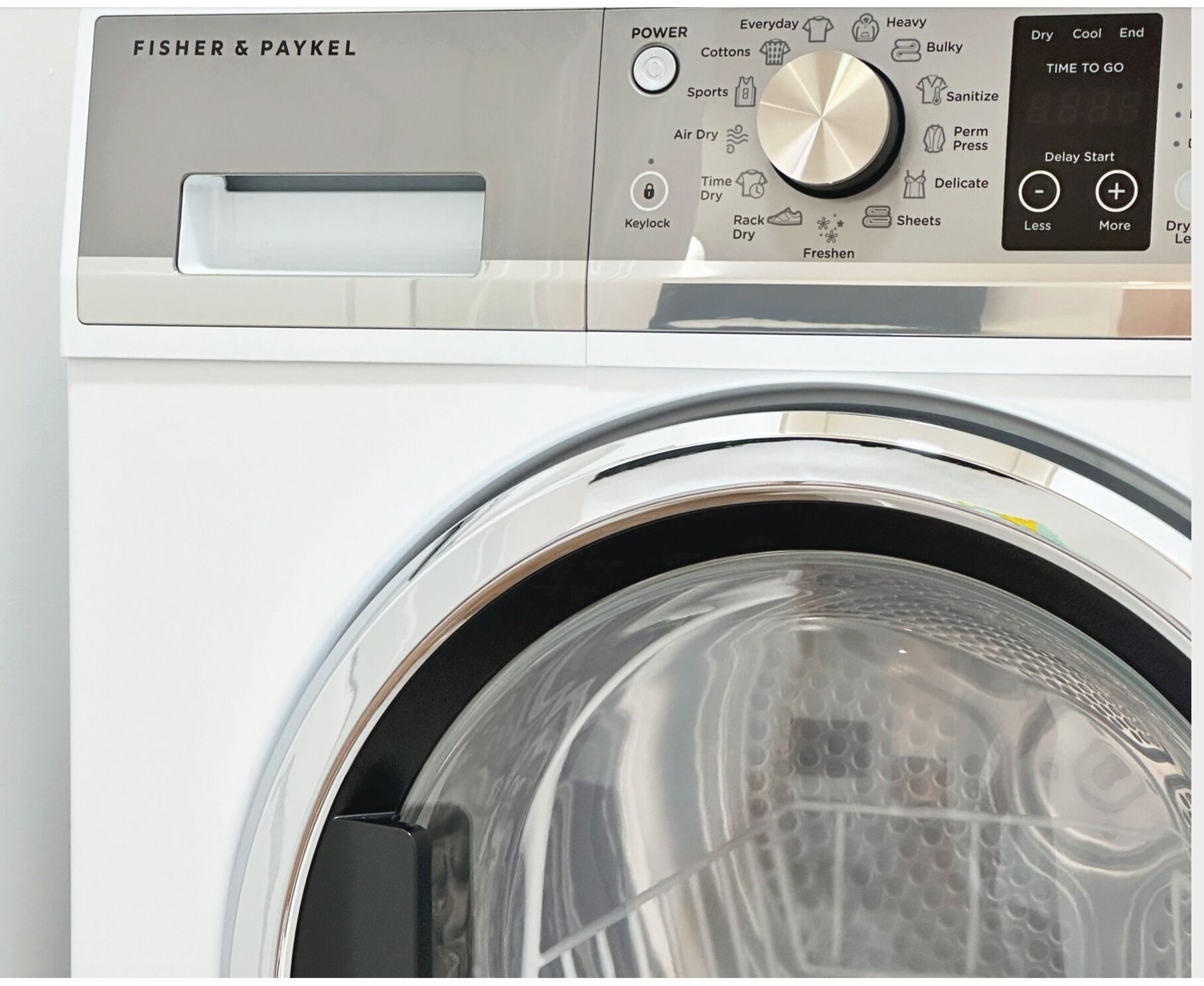 A Fisher & Paykel washing machine with a control panel featuring various settings and a timer display.