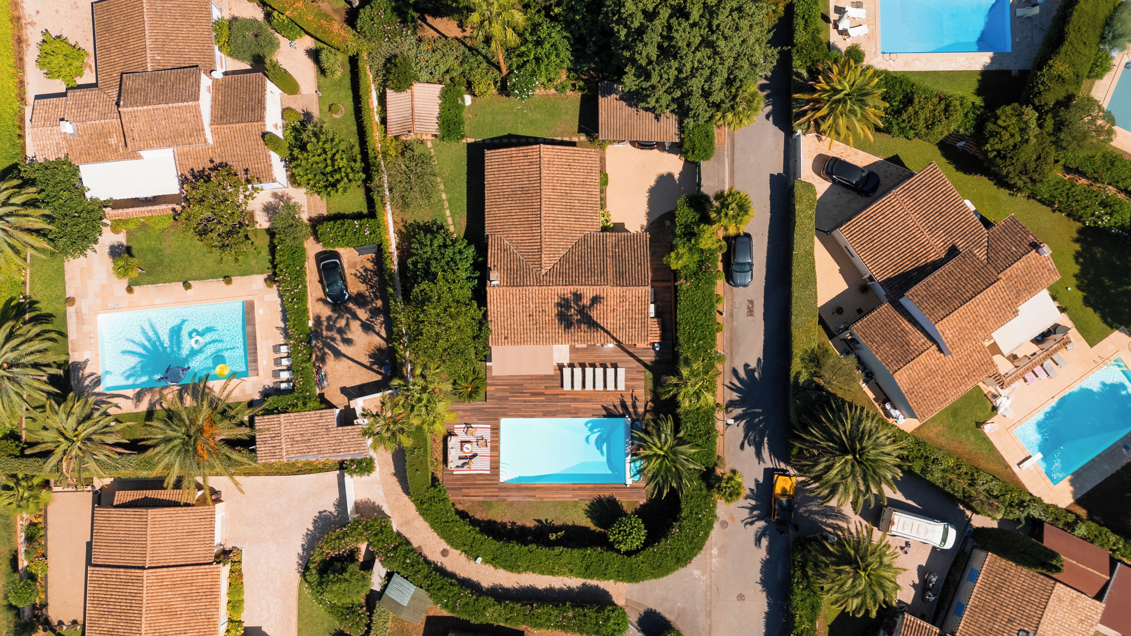 Vista aérea de una zona residencial con varias casas, una piscina y un jardín bien cuidado.