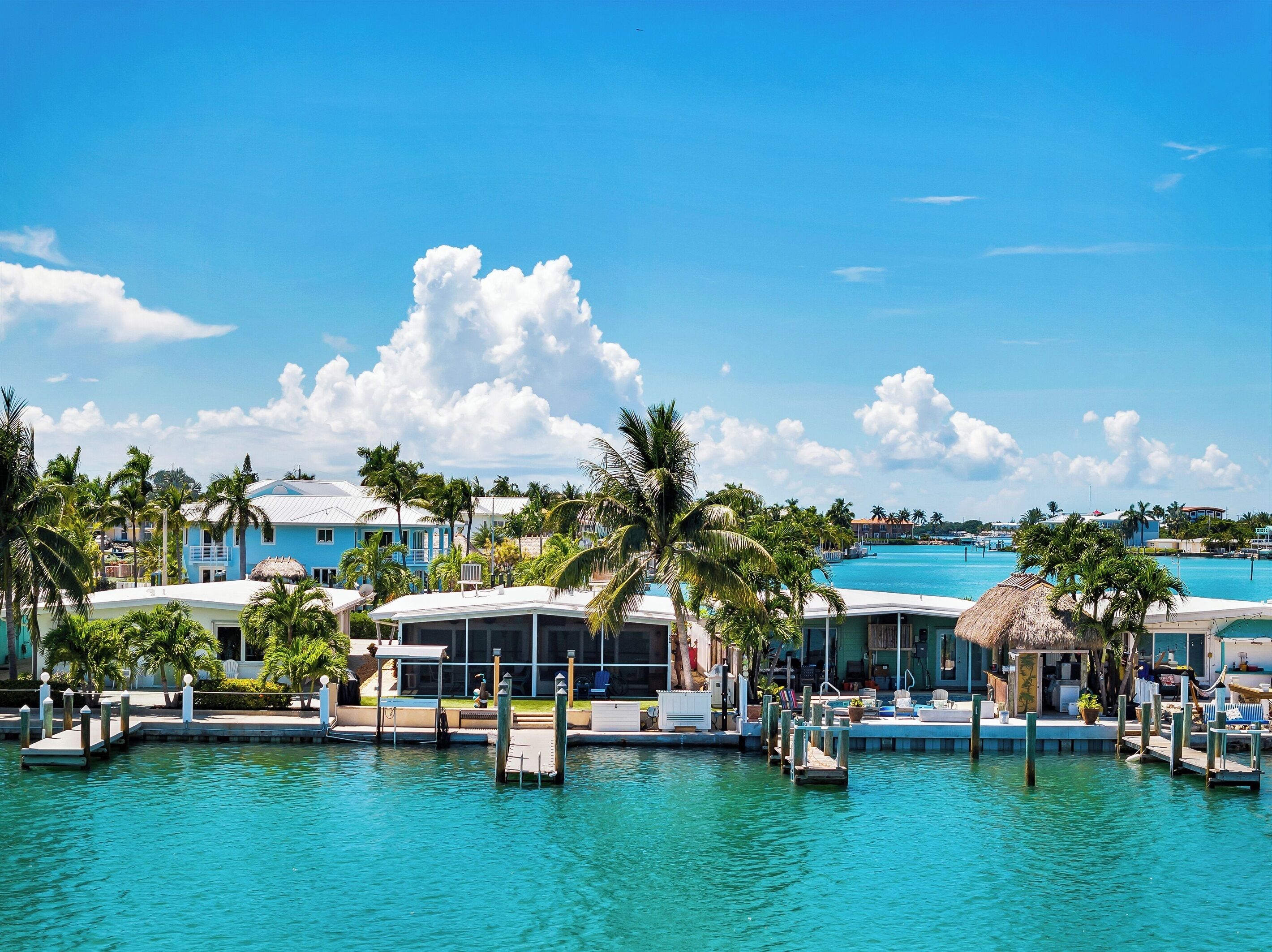 Resort com marina, águas azul-claras e palmeiras.