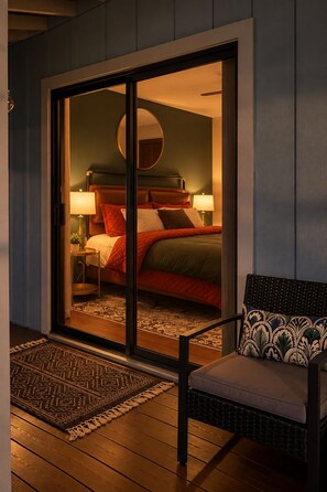 Ein Hotelzimmer mit einem Bett, einem Sessel, einem Nachttisch und einem großen Fenster.