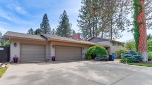 A two-story house with a garage, a driveway, and a well-maintained lawn. - Spokane Valley Escape (Spokane Valley)