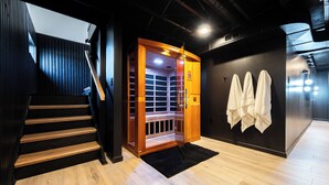 A modern interior with a wooden staircase, a glass elevator, and a wall-mounted towel rack. - Modern 4BR Home on Golf Course + Sauna Close to Campus, Dining & Entertainment (Greencastle)