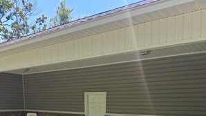 An outdoor patio area with a brick wall, a door, a basketball hoop, and outdoor furniture including a table and chairs. - Rainwaters Bunkhouse - Close to Crystal Springs and Lake Ouachita
 (Royal)