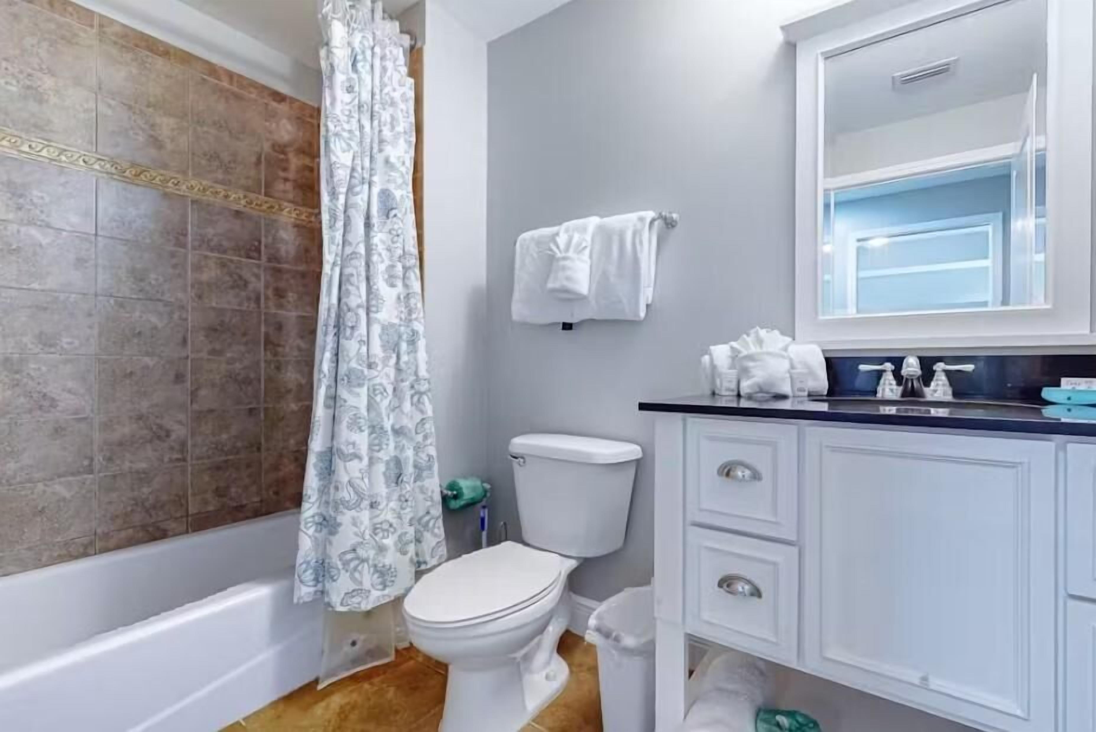 Une salle de bain équipée d’une baignoire, de toilettes et d’un meuble-lavabo avec un miroir.