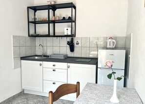 Frigorífico, microondas, cafetera o tetera y mesa de comedor