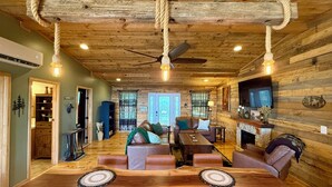 A rustic interior with a wooden dining table, leather sofas, and a fireplace. - Tranquil Escape: Hot Tub, Scenic Views, Family Fun (Ranger)