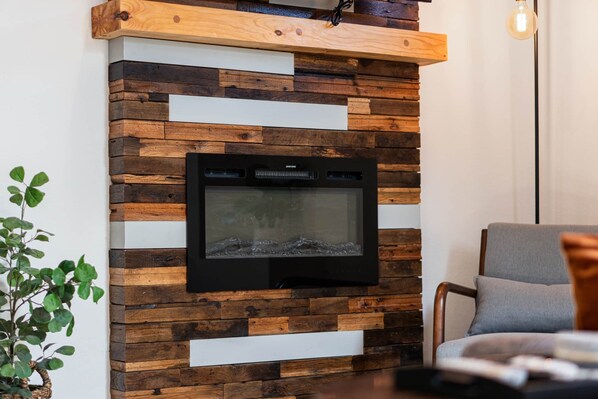 A modern living room with a built-in fireplace, wooden wall paneling, and a comfortable seating area.