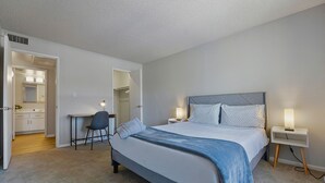 Ein Schlafzimmer mit Bett, Nachttischen, Schreibtisch und Stuhl.