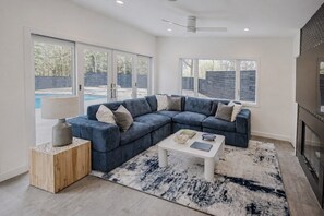 Una sala de estar moderna con un sofá modular, una mesa de centro y un televisor.