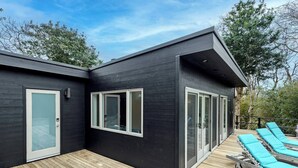Een modern huis met een terras en buitenmeubels.