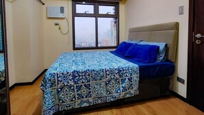 Une chambre à coucher avec un lit, une fenêtre et un luminaire au plafond.