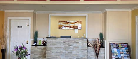 A reception area with a stone counter, a wall-mounted artwork, a sign indicating 'Office Use Only,' and a stand with brochures.