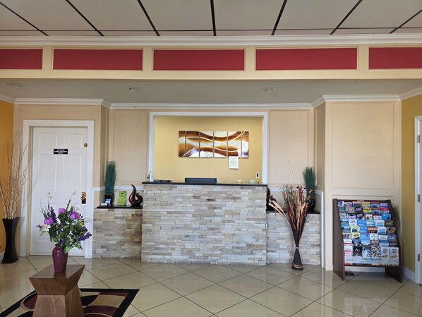 A reception area with a stone counter, a wall-mounted artwork, a sign indicating 'Office Use Only,' and a stand with brochures.