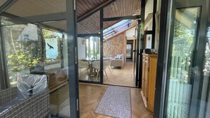 A modern interior with a dining area, a sofa, and a view through glass doors. - Vacation home-Nature-Elbe-View-Fully equipped (Magdeburg)