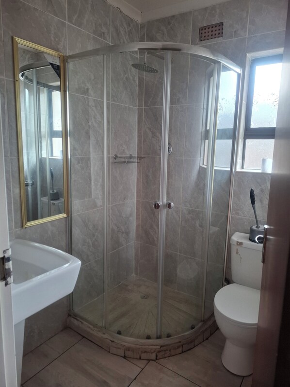 Regadera, toallas, papel de baño 